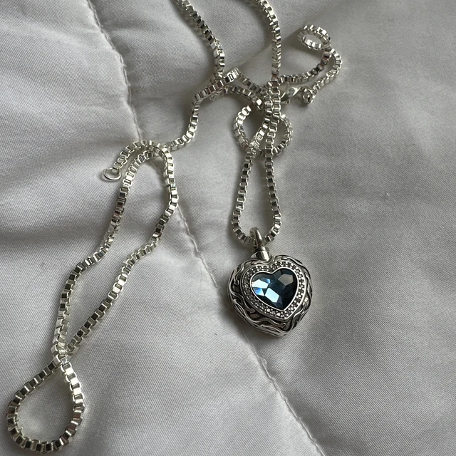 Customer photo showing the Blue Heart necklace chain and pendant on soft fabric